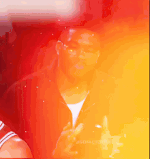 a man is giving a peace sign with a red and yellow background