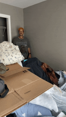 a man standing next to a pile of cardboard boxes