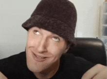 a man wearing a hat is smiling and making a funny face .