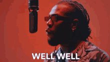 a man wearing glasses is singing into a microphone with the words well well above him
