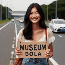 a woman holds up a sign that says museum bola