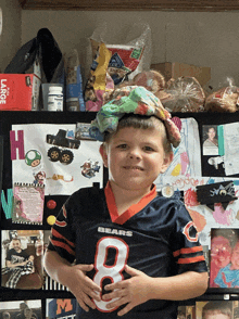 a young boy wearing a bears jersey with the number 8 on his chest