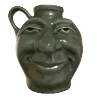 a green pitcher with a smiling face and big teeth