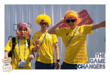 a group of people wearing yellow shirts and wigs are standing in front of a sign for the south olympic games