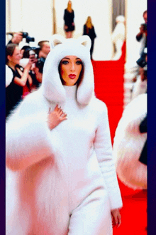 a woman in a white fur coat with a cat hood