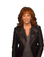 a woman with red hair is wearing a black jacket