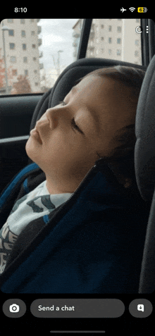 a child is sleeping in a car seat with the time 8:10 on the screen