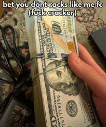 a person is holding a stack of 100 dollar bills tied together with rubber bands