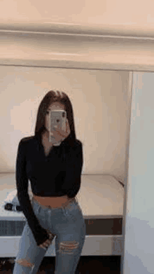 a woman is taking a picture of herself in the mirror .