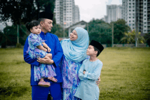 a family standing in a field wearing blue and purple clothes