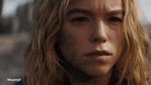 a close up of a woman 's face with #supergirl written below her