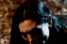 a close up of a person 's face in a dark room with their eyes closed .