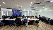 a man sits at a desk in an office with a sign on the wall that says ' a man '