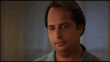 a close up of a man 's face with a blue shirt
