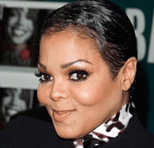 a close up of a woman 's face in front of a sign that has the letter b on it