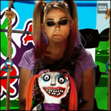 a woman with pigtails is holding a joker doll