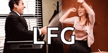 a man and a woman are dancing in front of a television with the word lfg written on it .