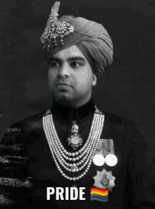 a black and white photo of a man wearing a turban and pearls with the word pride written above him