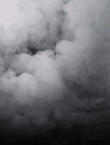 a black and white photo of smoke coming out of a hole in the ground