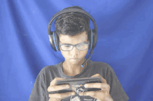 a young boy wearing headphones and glasses is playing a video game