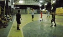 a group of people are playing a game of basketball on a court with a sign that says ' coca-cola '