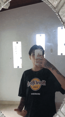 a person wearing a hard rock t-shirt takes a selfie