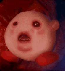 a close up of a kirby doll with its mouth open .