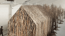 a building made out of sticks with a roof