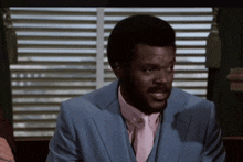a man in a blue suit with a pink tie