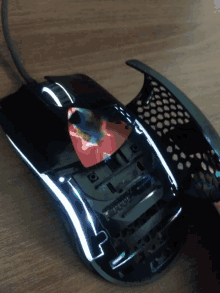 a black computer mouse with a rainbow colored sticker on it