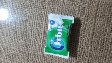 a package of orbit gum sits on a brown cloth