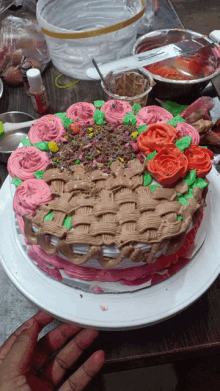 a cake with pink and green frosting and flowers on top