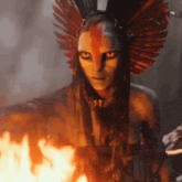 a woman with feathers on her head looks at the camera