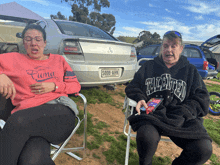 two women sitting in front of a car with the license plate s006 ahk