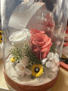 a glass container filled with flowers and lights