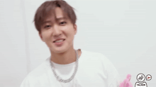 a man wearing a white shirt and a silver chain around his neck is being touched by another person 's hand ..