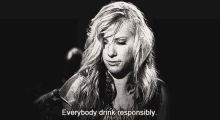 a black and white photo of a woman with the words `` everybody drink responsibly '' written next to her .