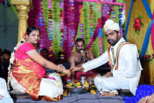 a man singing into a microphone while a woman holds his hand during a wedding ceremony