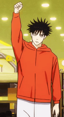 a man in an orange hoodie holds his fist in the air