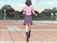 a girl in a pink jacket and purple skirt is walking down a brick walkway