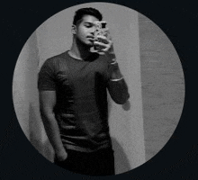 a man is taking a selfie with his cell phone in a mirror .