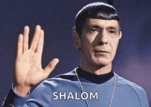 a man in a blue sweater waves his hand with the word shalom below him