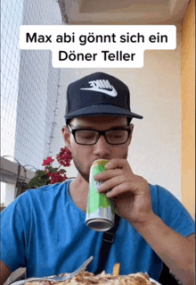 a man wearing glasses and a nike hat is drinking from a can