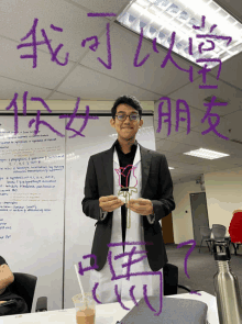 a man stands in front of a white board with chinese writing