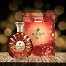 a bottle of remy martin xo cognac is on a wooden table .