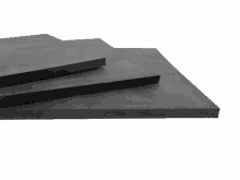 three pieces of black foam are stacked on top of each other on a white background