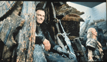 a man with long hair is sitting in a wooden chair