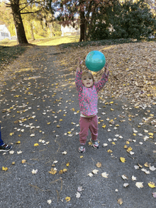 a little girl holding a blue balloon in her hands