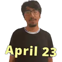 a man wearing glasses and a black shirt that says april 23 on it
