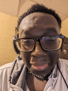 a man wearing glasses and headphones with a panda sticker on the wall